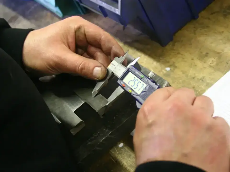Digital caliper checking a machined part